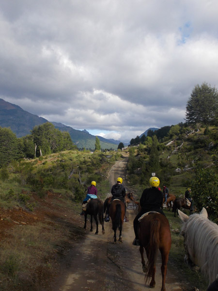 equestrians horseback riding towards the mountains in patagonia