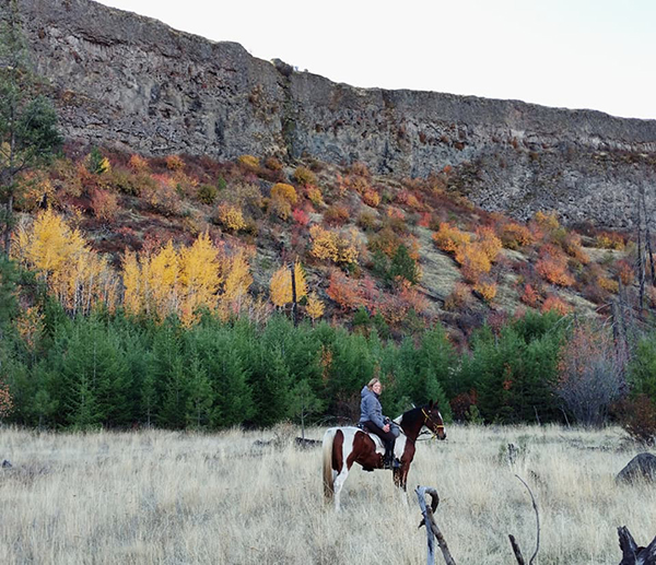 woman riding horse in canyon in the fall riverside state park washington