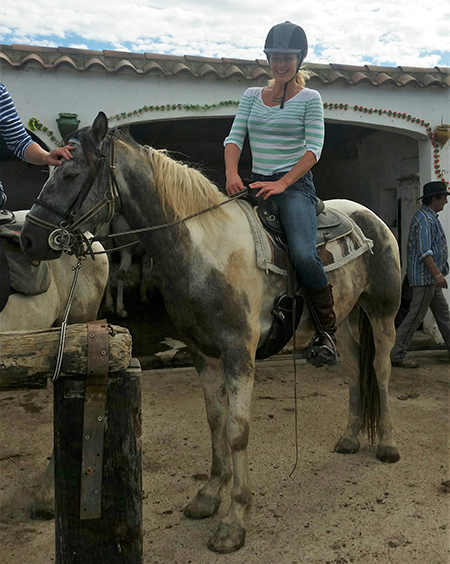 young woman riding spanish quarter horse cross in camargue france