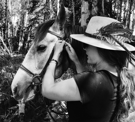 Kate checking the harnesses on her horse before horseback riding in Keystone, Colorado