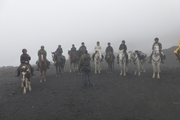 equestrians in the mist riding mount etna in sicily