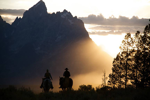 sunset scenic of wranglers riding at triangle x ranch jackson hole wyoming