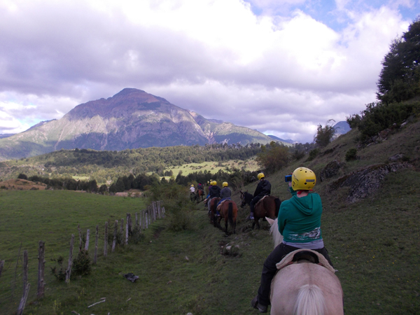 group of equestrians trail ride into the mountains of patagonia