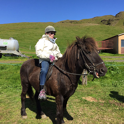 senior woman horseback riding in iceland